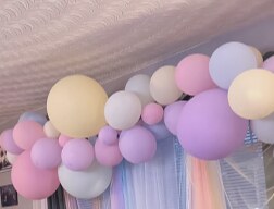 Pastel balloon garland over a sheer rainbow backdrop