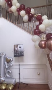 Burgundy, white and rose gold balloon garland along a staircase