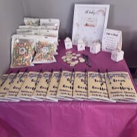 Party favor table with pink tablecloth and custom wrapped treats