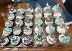 Tray of cupcakes topped with blue, white and purple frosting