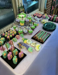Green, purple and pink dessert table with cupcakes, cake pops and dipped pretzel rods